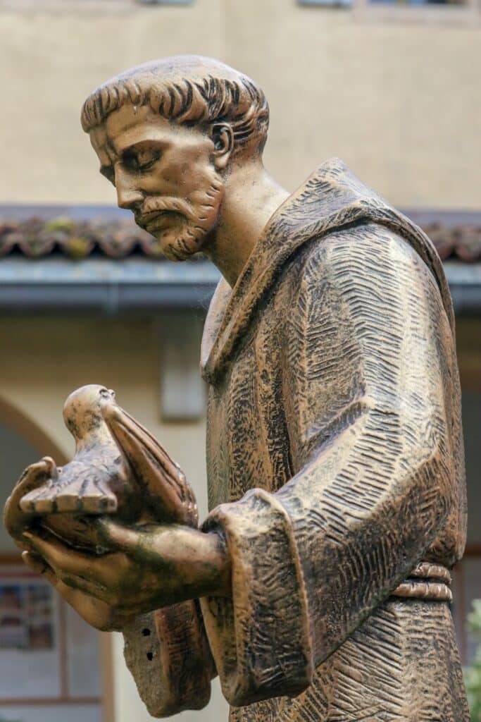 Bronze statue of a monk holding a bird