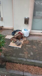 Una coperta sul marciapiede davanti alla banca: la povertà che non possiamo più ignorare