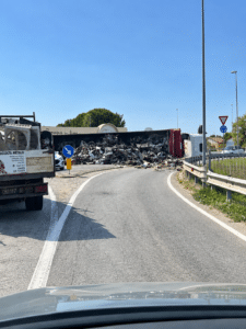Tir si ribalta alla rotonda Secondo Casadei: perde il carico di rottami